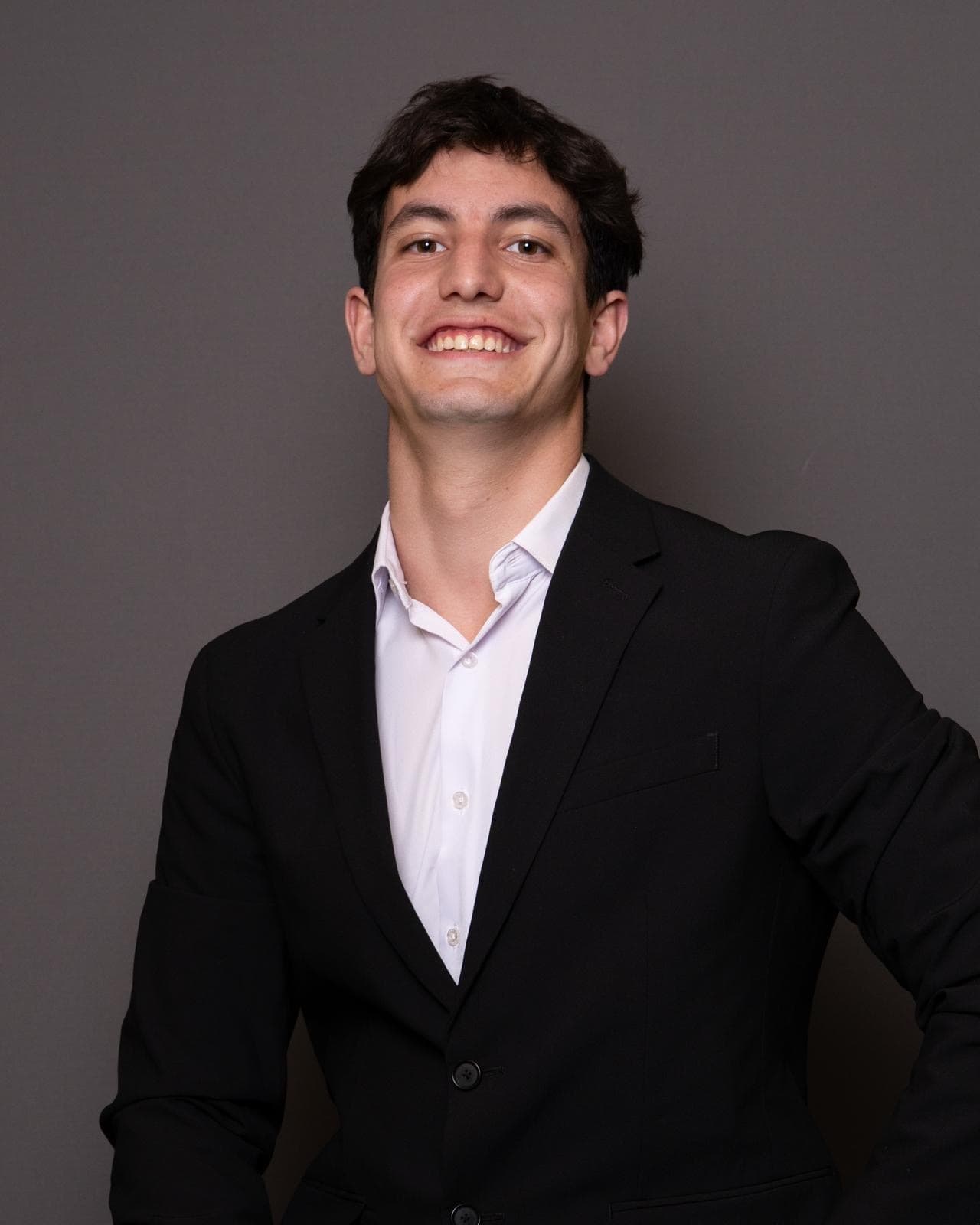 Lucas Cherniak smiling in a professional headshot, wearing a suit.