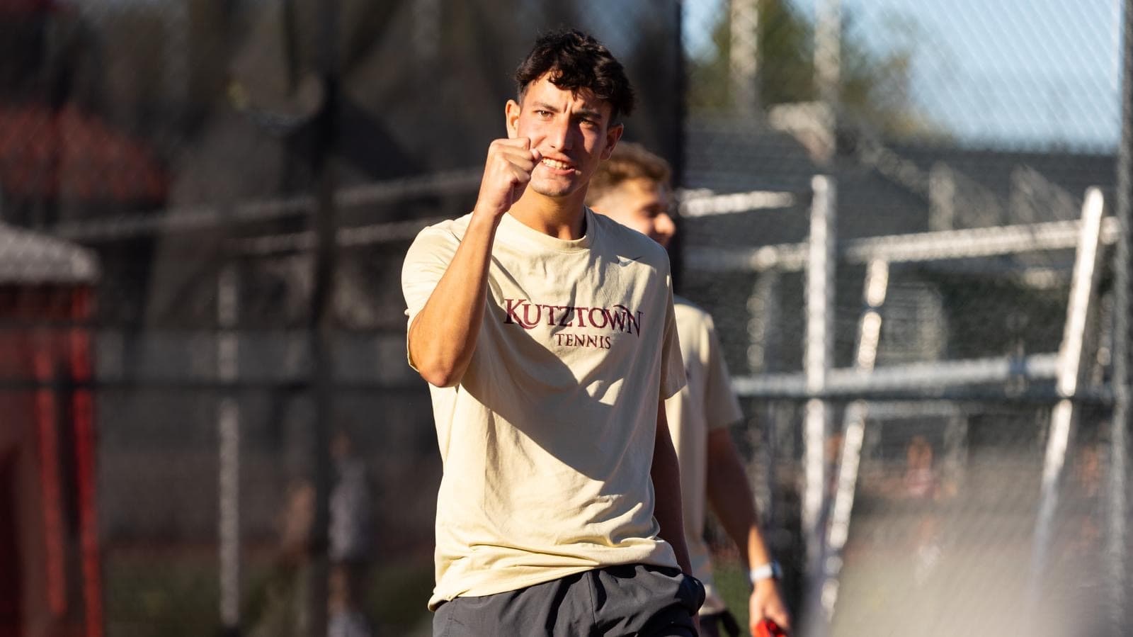 Lucas Cherniak celebrating with a fist pump at a Kutztown Tennis match.